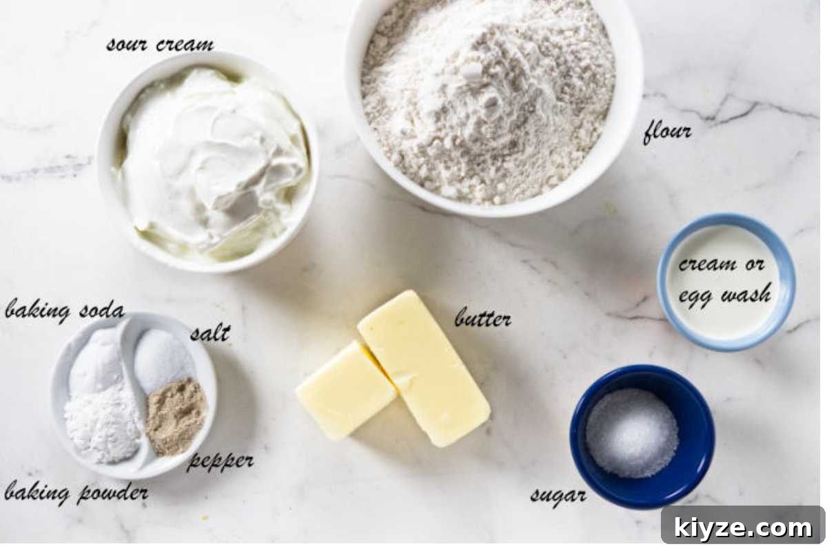 Flaky Sour Cream Biscuits Recipe for Perfect Homemade Biscuits 4 Overhead view of assorted baking ingredients arranged on a white surface.
