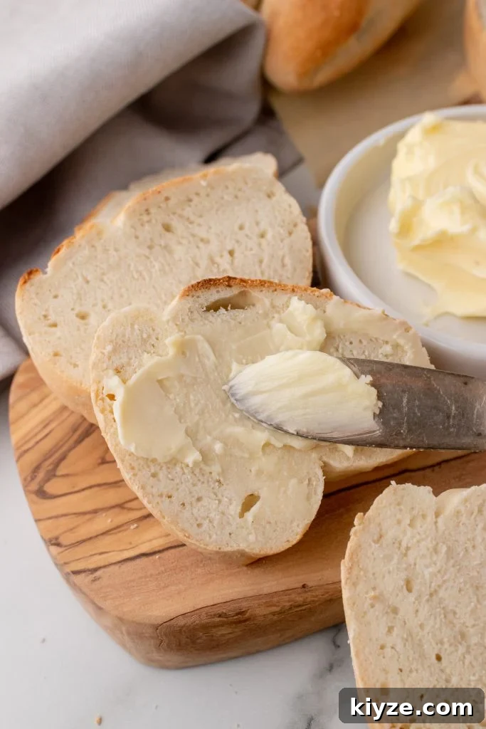 30-Minute Crusty Baguettes: Foolproof Recipe for Homemade Bread 13 butter spread over a slice of crusty fool proof baguettes