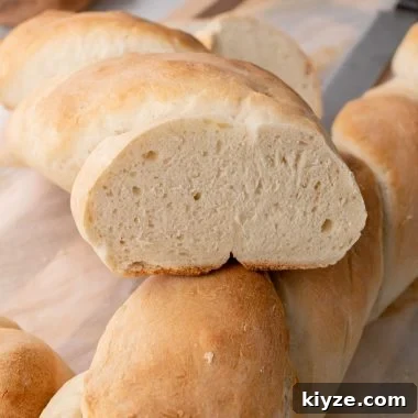 two golden brown, baked loaves of french baguette sliced in half
