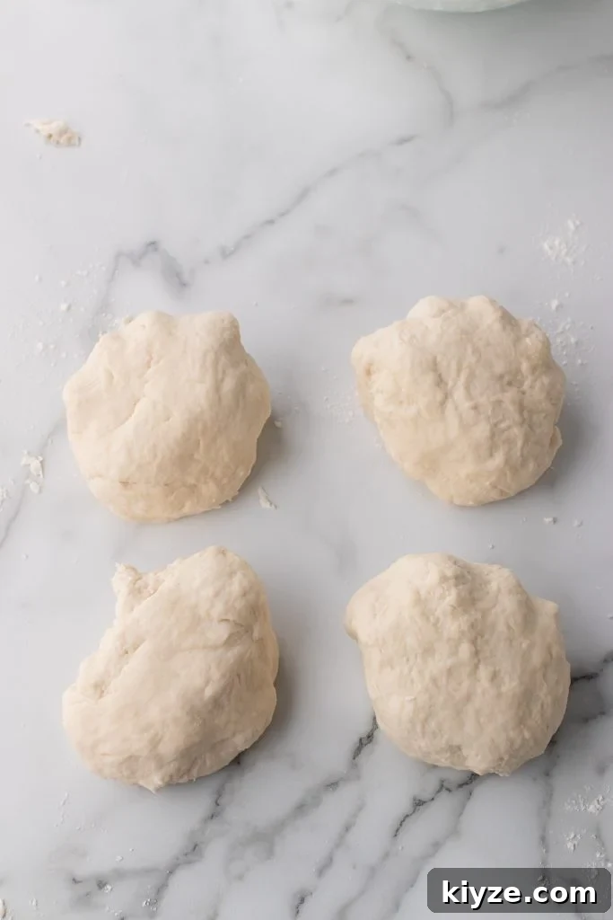 30-Minute Crusty Baguettes: Foolproof Recipe for Homemade Bread 8 four small balls of fool proof baguette dough on a marbled countertop