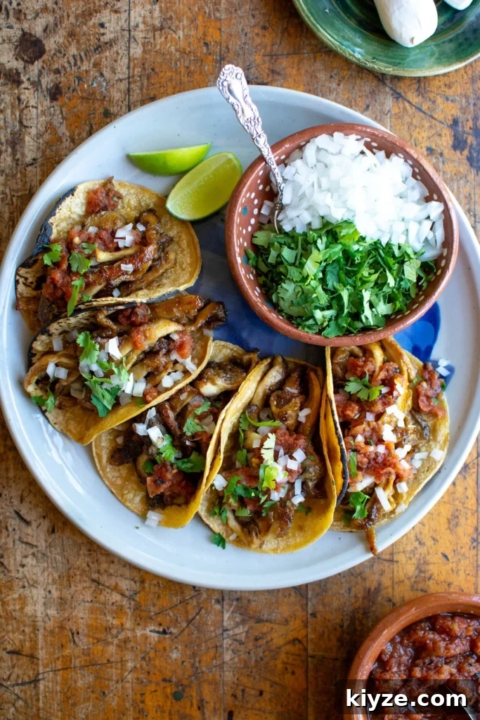 Vegan Oyster Mushroom Carnitas Tacos — Smoky Plant-Based Filling 18 A plate of mushroom carnitas tacos with a bowl of onions and cilantro