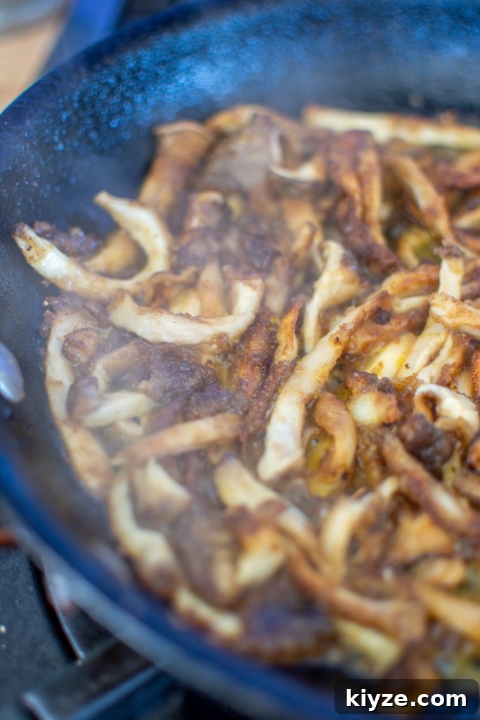 Vegan Oyster Mushroom Carnitas Tacos — Smoky Plant-Based Filling 10 Oyster mushrooms cooking in a black pan