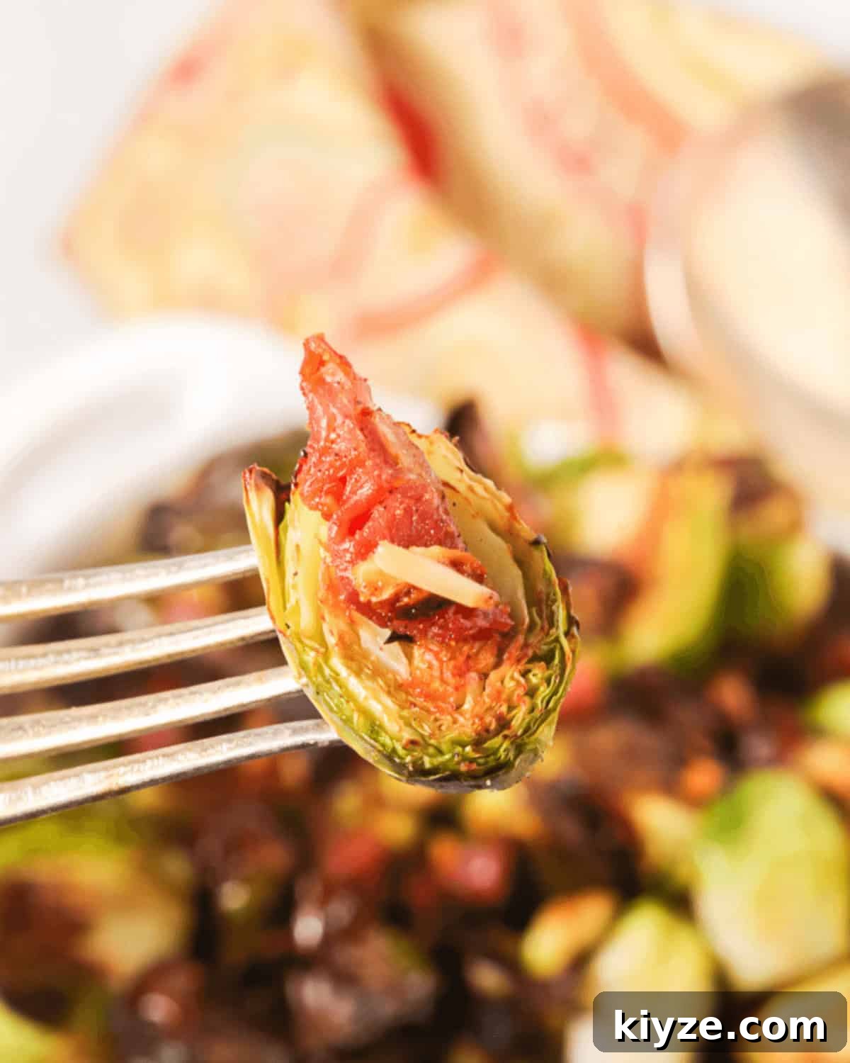 Crispy Roasted Brussels Sprouts with Prosciutto and Balsamic Glaze 3 A fork with a vegetables on it.