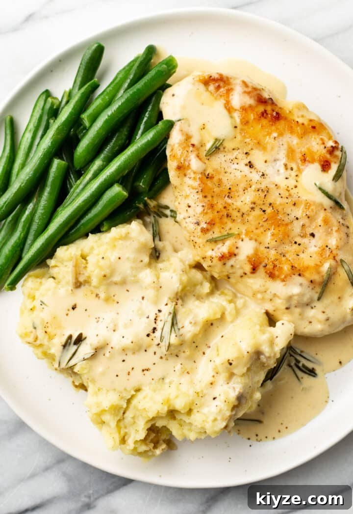 Creamy Dijon and Rosemary Chicken Skillet Recipe 6 a plate with chicken in sauce, green beans, and mashed potatoes