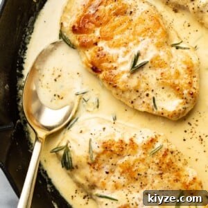 Creamy Dijon and Rosemary Chicken Skillet Recipe 7 closeup of rosemary dijon chicken in a skillet with a serving spoon