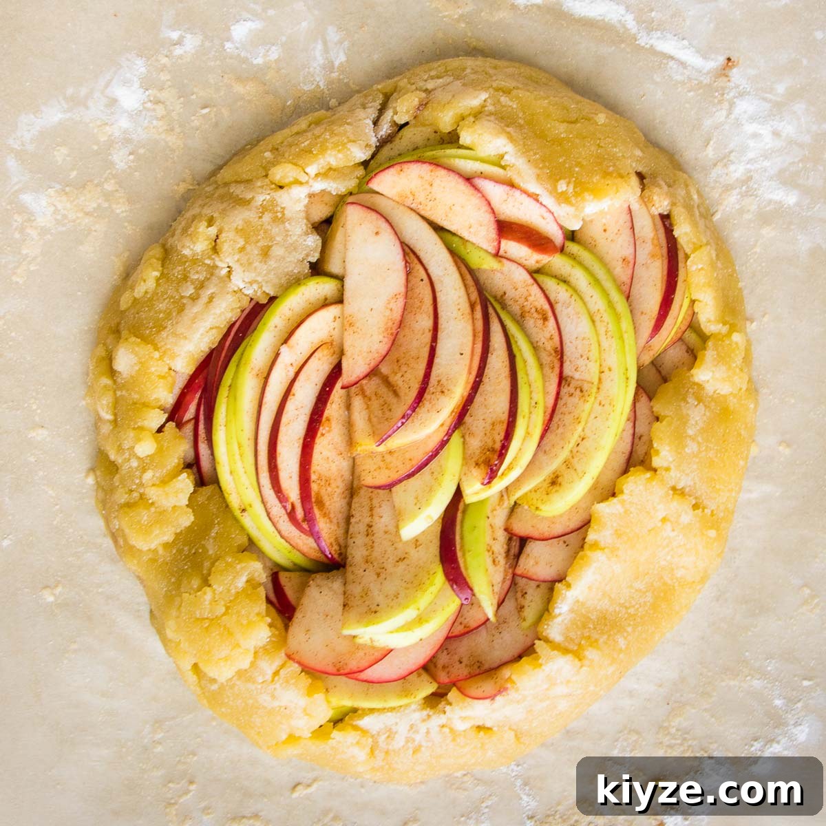 Pie crust filled with sliced apples with a free form fold along the edges to produce a rustic galette.