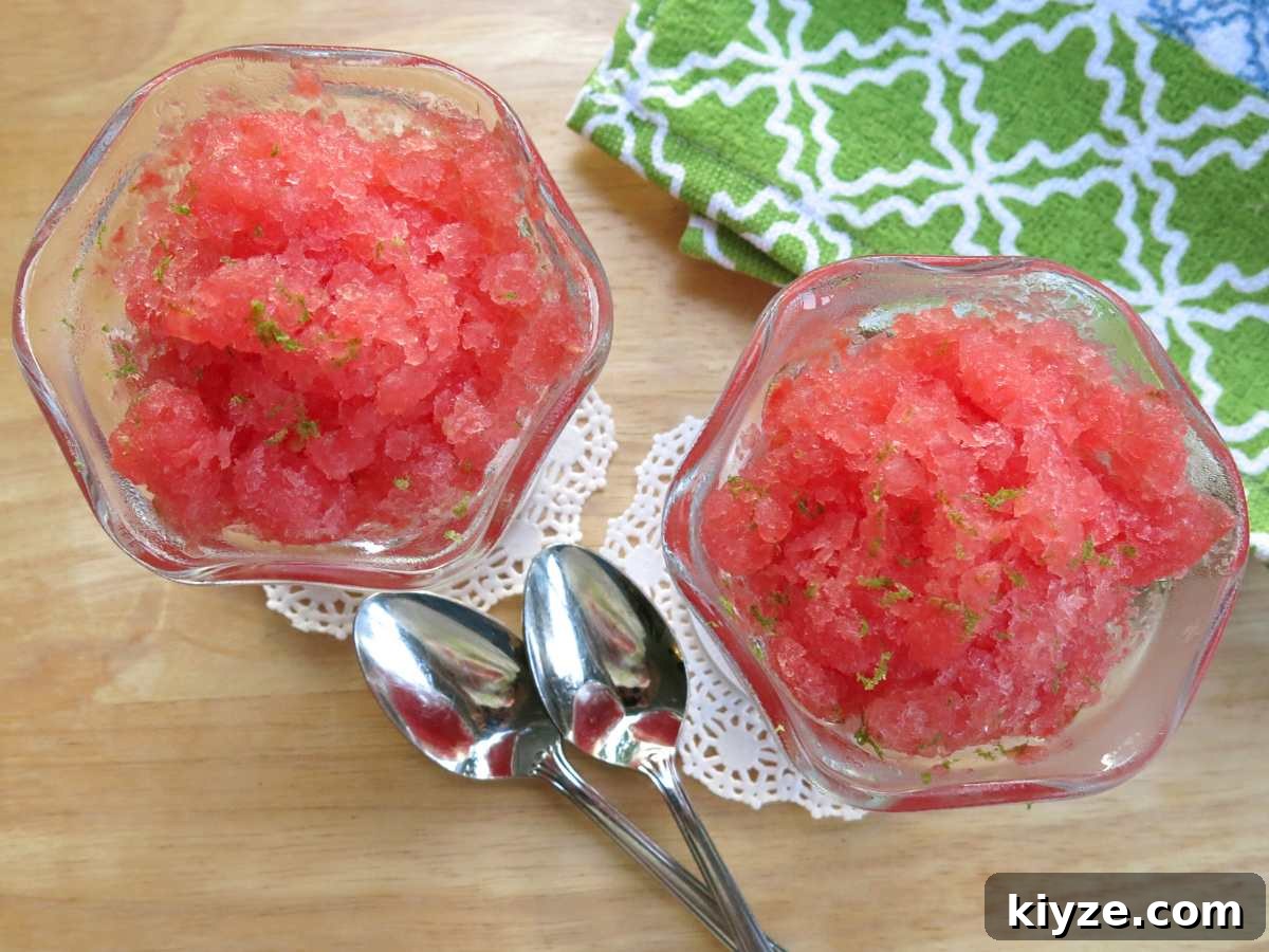 Two glass dishes with watermelon granita with two spoons and a breen patterned napkin.