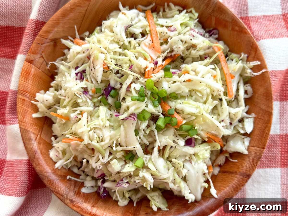 Southern vinegar coleslaw in a brown bowl on a red checkered napkin.