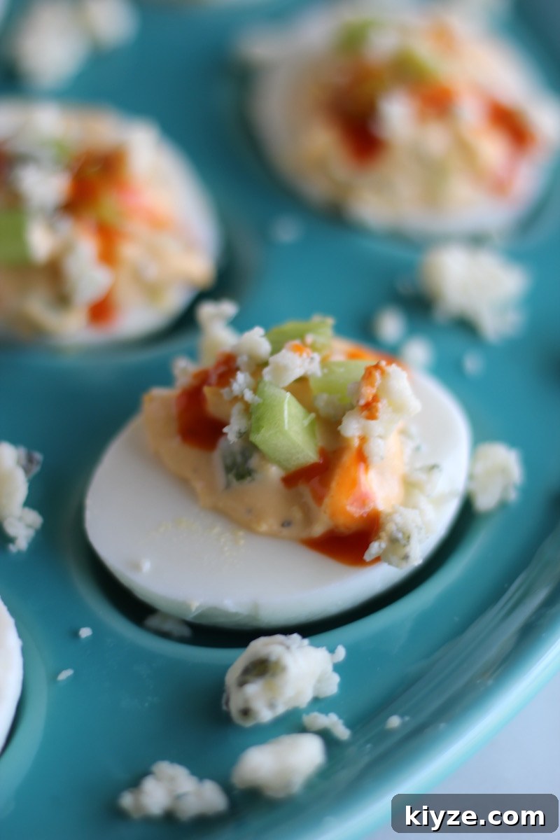 Buffalo Deviled Eggs - a five-ingredient, super easy deviled egg recipe that packs a punch with hot sauce and blue cheese! Party in your mouth! | fedandfulfilled.com
