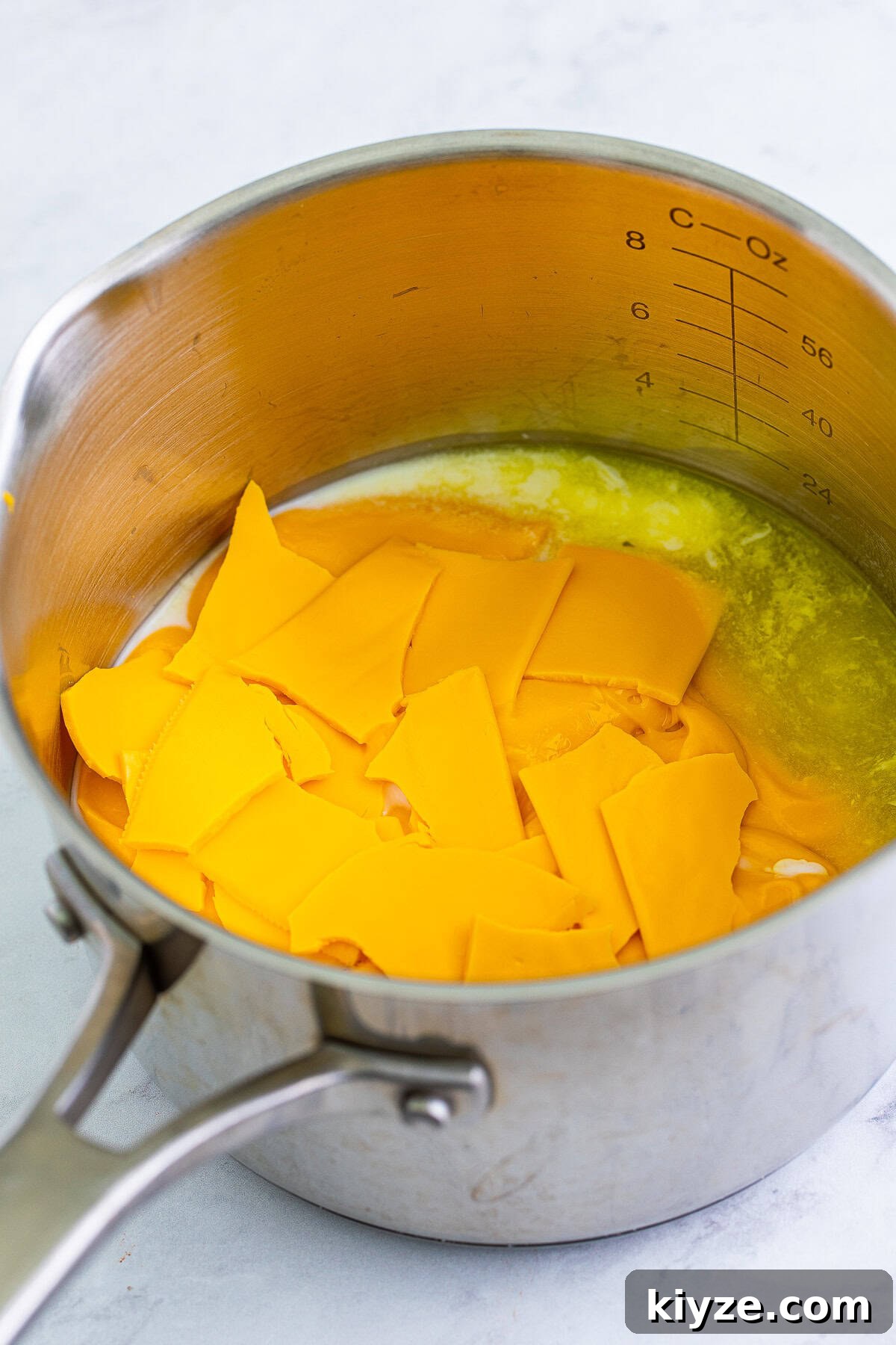 Cheez Whiz, American cheese, and jalapeno juice in a saucepan to make nacho cheese.