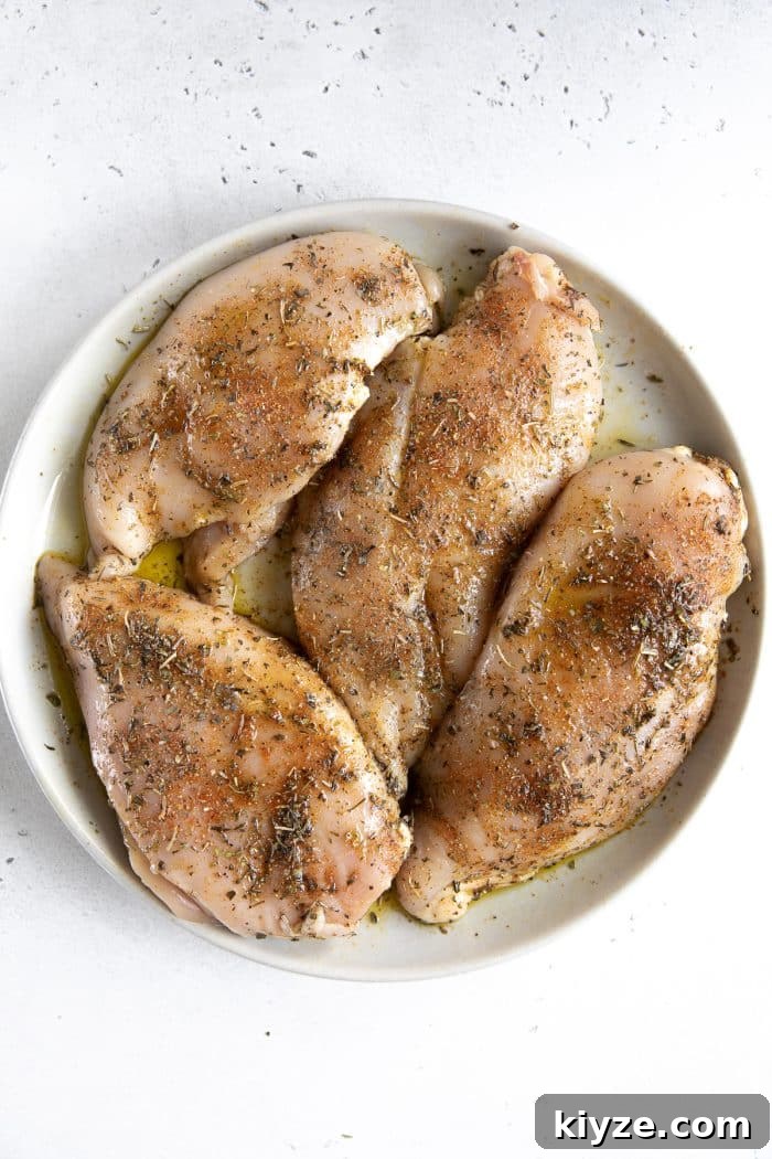 Instant Pot Chicken and Potatoes Dinner Recipe 3 Four seasoned chicken breasts on a large plate.