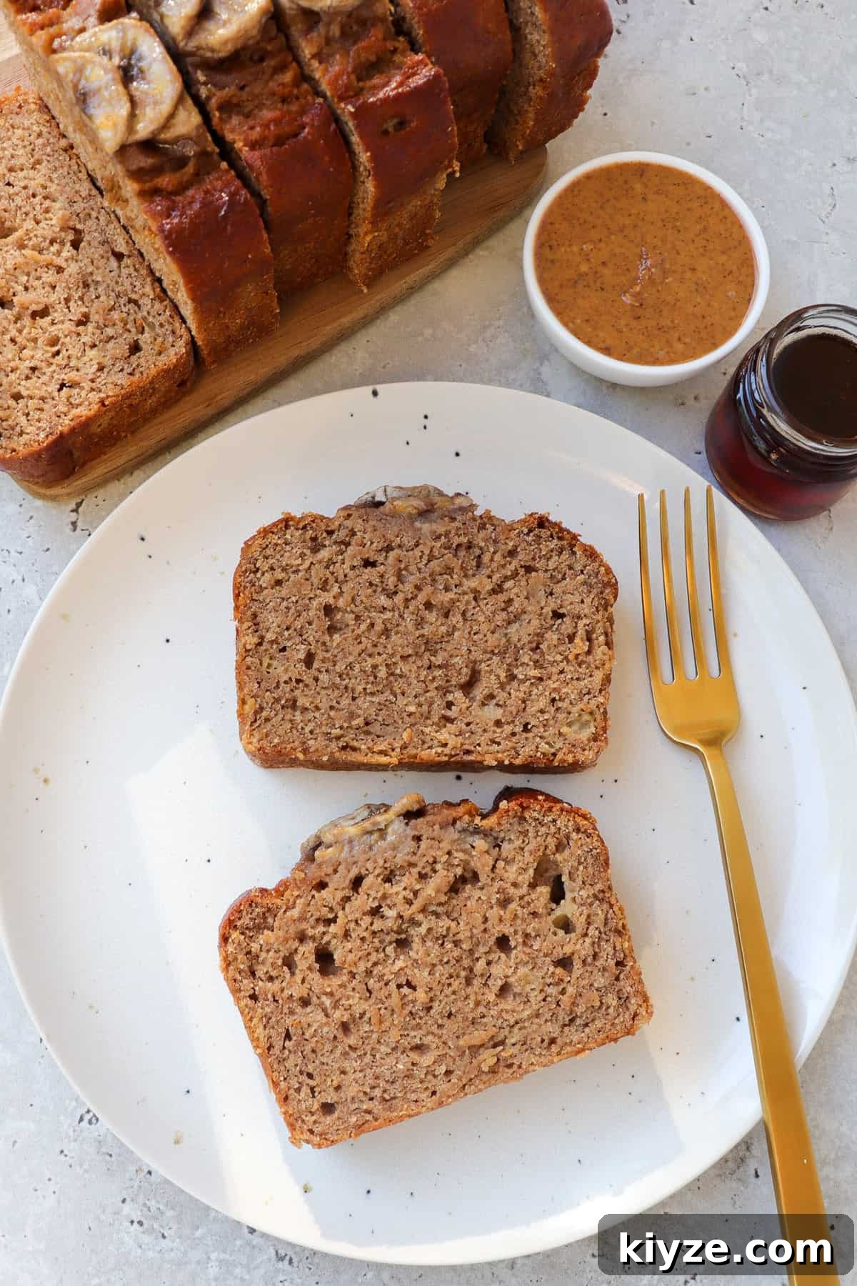 5-Ingredient Vegan Banana Bread Recipe 3 Two slices of 5 ingredient banana bread on a plate with a fork.