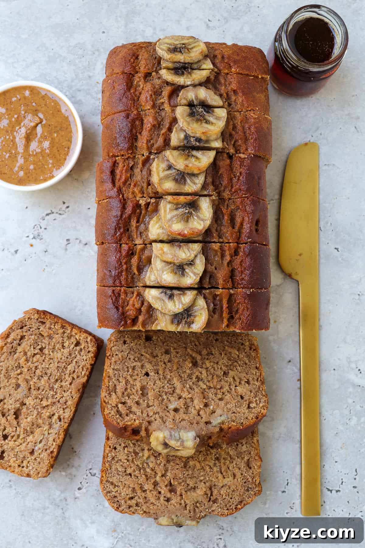 5-Ingredient Vegan Banana Bread Recipe 8 Vegan banana bread sliced up with almond butter and maple syrup in bowl on the side.