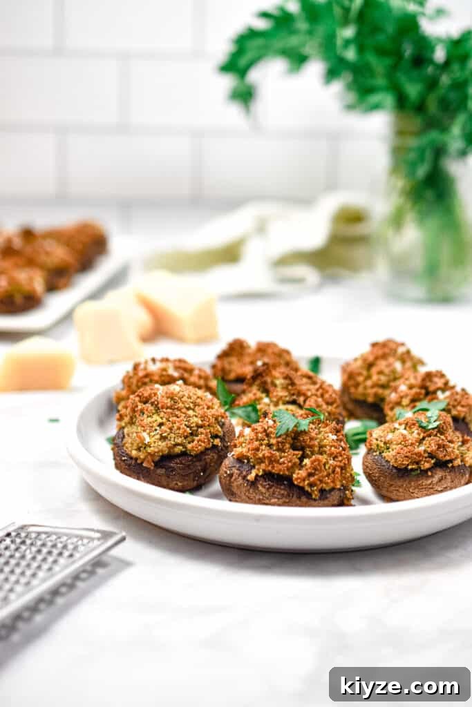 A head on view of a plate of Italian stuffed mushrooms and a bouquet of parsley in the background