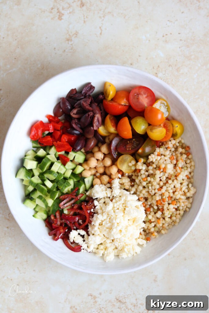 pearl couscous salad ingredients in bowl before tossing