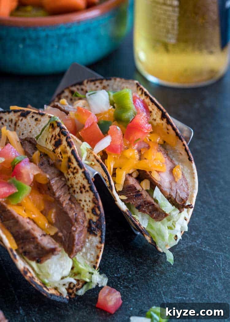 Cilantro-Lime Flank Steak Tacos with Charred Onions 5 Flank Steak Tacos with shredded cheese and pico de gallo