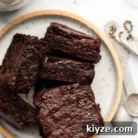 overhead shot of sliced fudgy gluten free brownies on a white plate