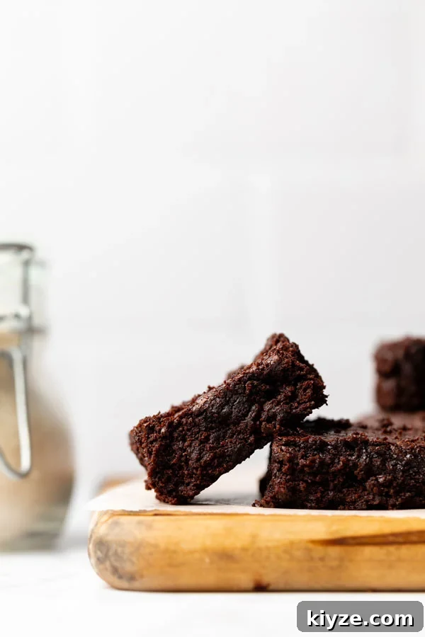 One-Bowl Fudgy Gluten-Free Brownies Recipe 3 gluten free brownies from scratch on a wood cutting board
