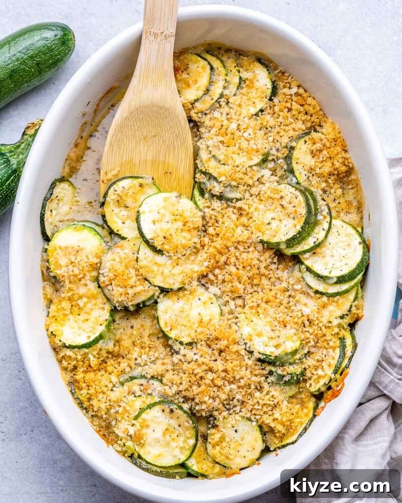 top view zucchini casserole dish with wooden spoon in it 