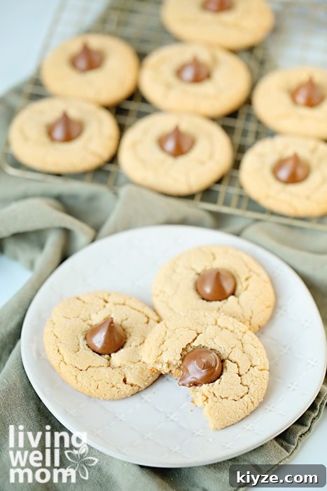 Gluten-Free Peanut Butter Blossom Cookies — Video Recipe & Tips 8 gluten-free peanut butter blossom cookies with hershey's kisses on a plate