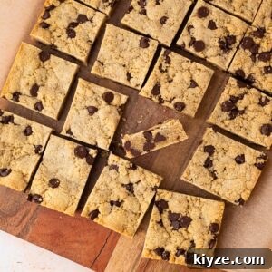 Bourbon Chocolate Chip Cookie Bars Recipe — Rich Boozy Dessert 12 Bourbon Chocolate Chip Cookie Bars cut into squares with a blondie center and chewy cookie like edges and a golden brown top.