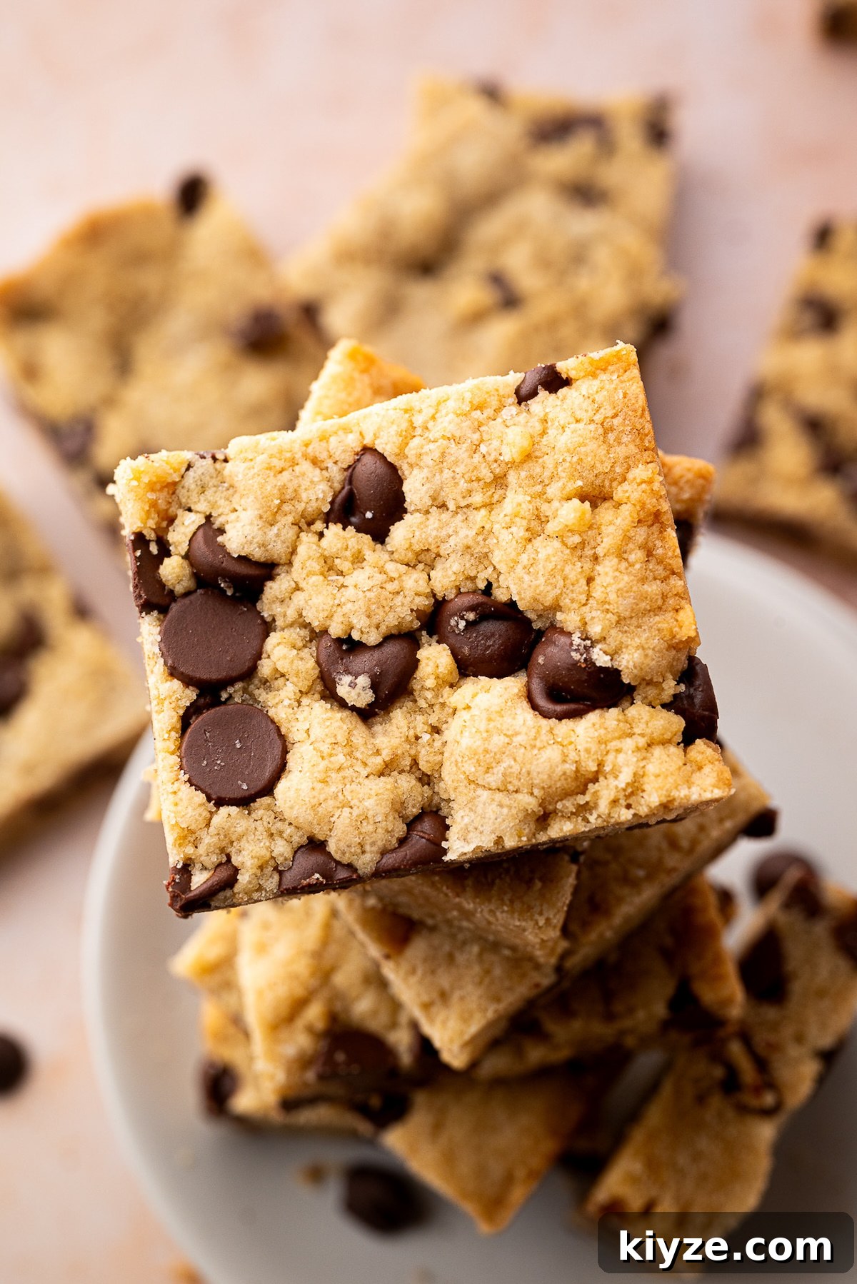Bourbon Chocolate Chip Cookie Bars Recipe — Rich Boozy Dessert 3 A stack of baked chocolate chip cookie bars with the perfect golden brown color.
