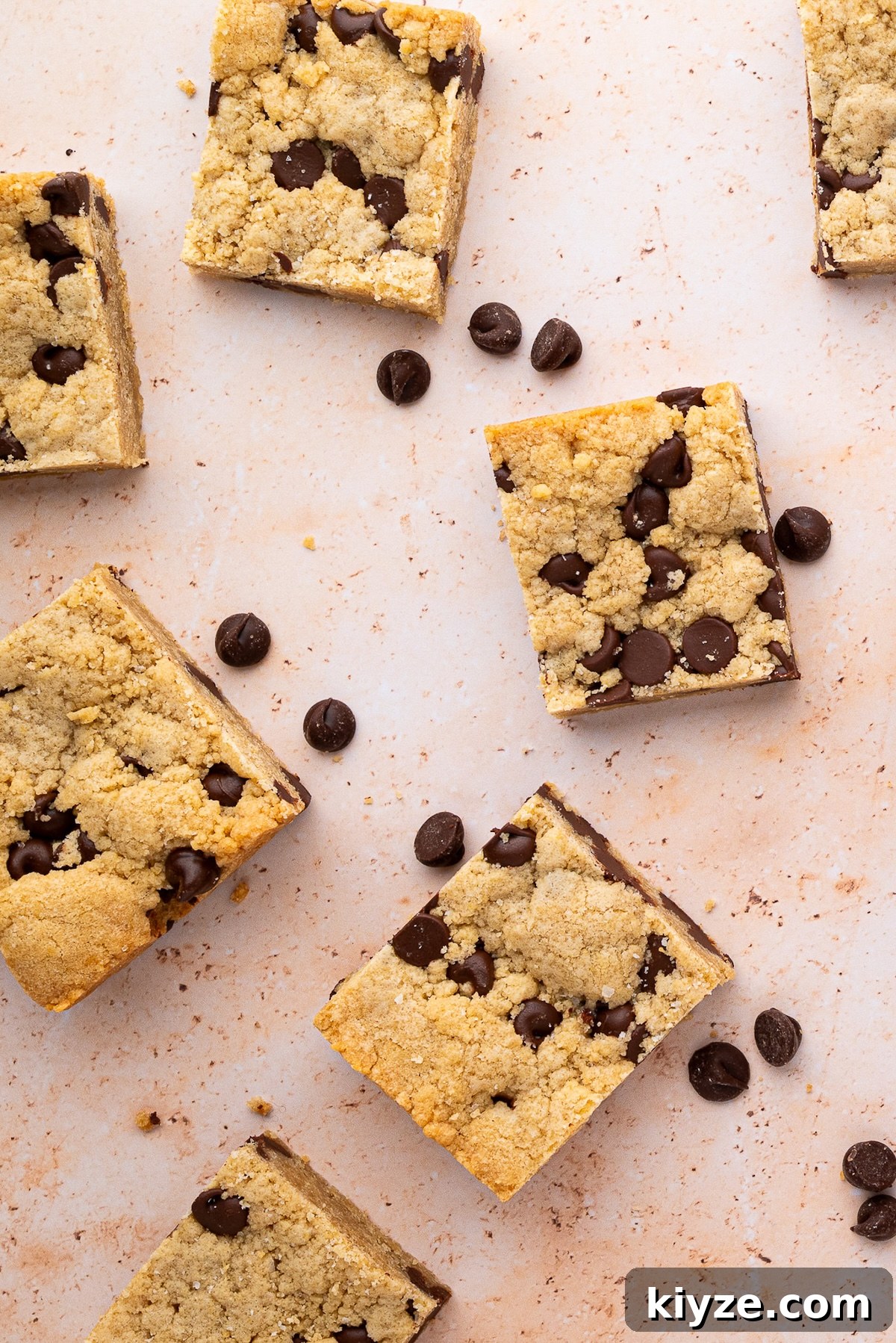 Bourbon Chocolate Chip Cookie Bars Recipe — Rich Boozy Dessert 4 Cut cookie bars and extra chocolate chips sprinkled around them.