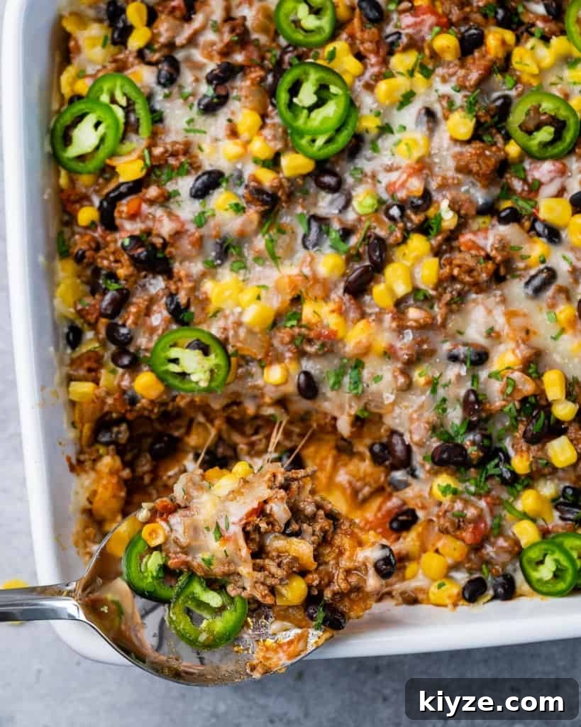 Cheesy Taco Casserole: One-Pan Mexican Dinner Recipe 7 Spooning out a serving of a taco bake.