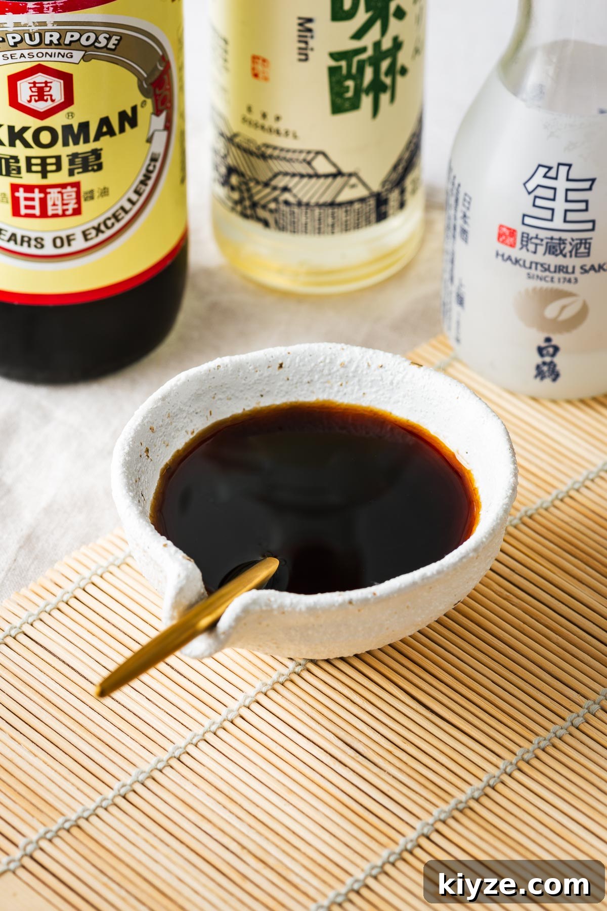 A bowl of sukiyaki sauce surrounded by ingredients, including Kikkoman soy sauce, mirin and sake.