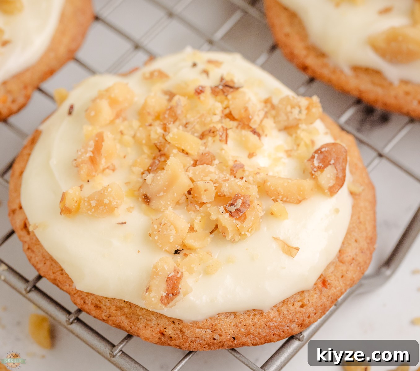 Carrot Cake Cookies with Cream Cheese Frosting Recipe 6 Carrot Cake Cookies topped with a cream cheese frosting on a cooling rack