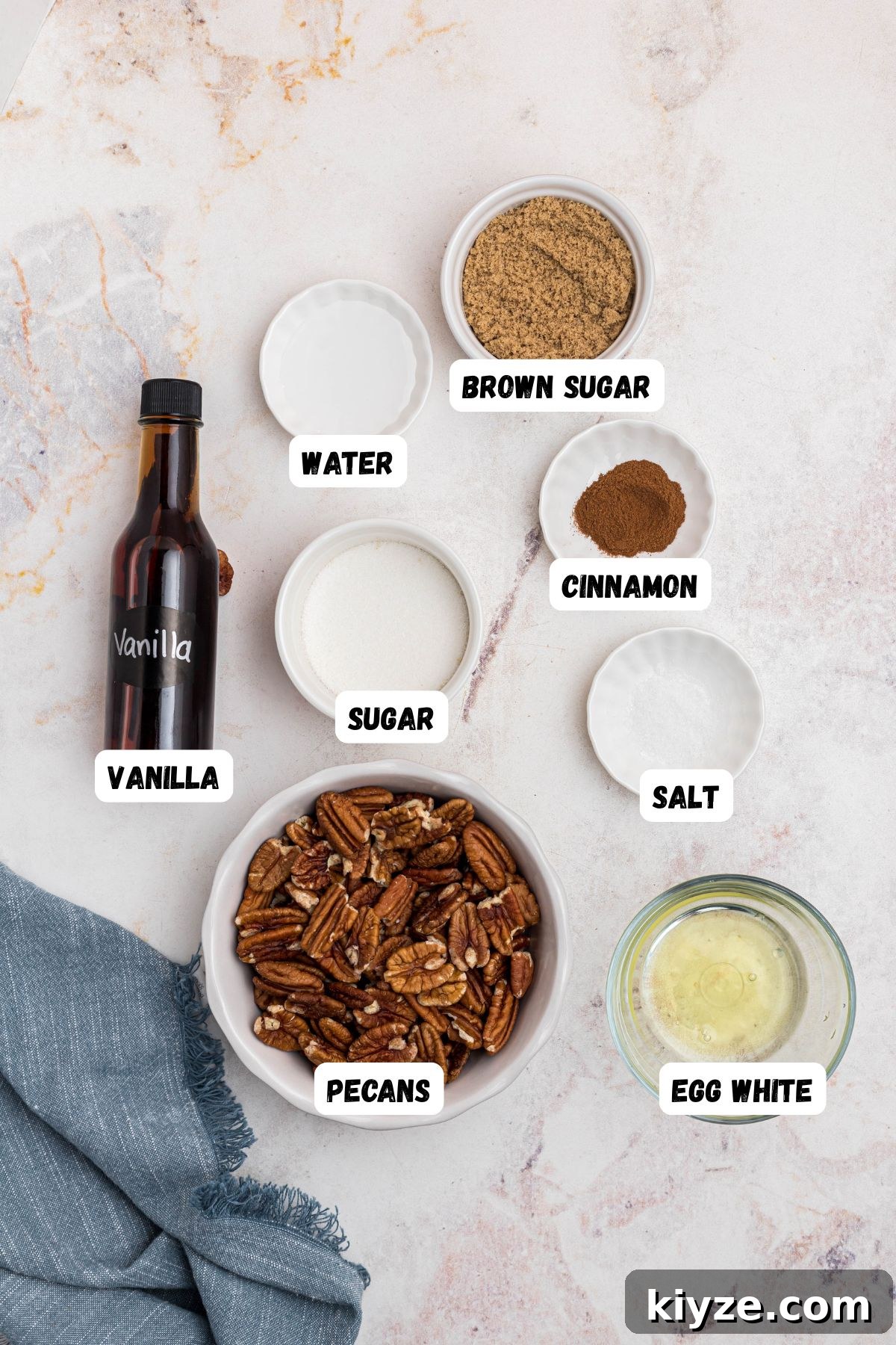 Cinnamon Sugar Candied Pecans Recipe for Snacking & Gifts 3 Ingredients needed to make candied pecans measured into small bowls and labeled on a marble table.