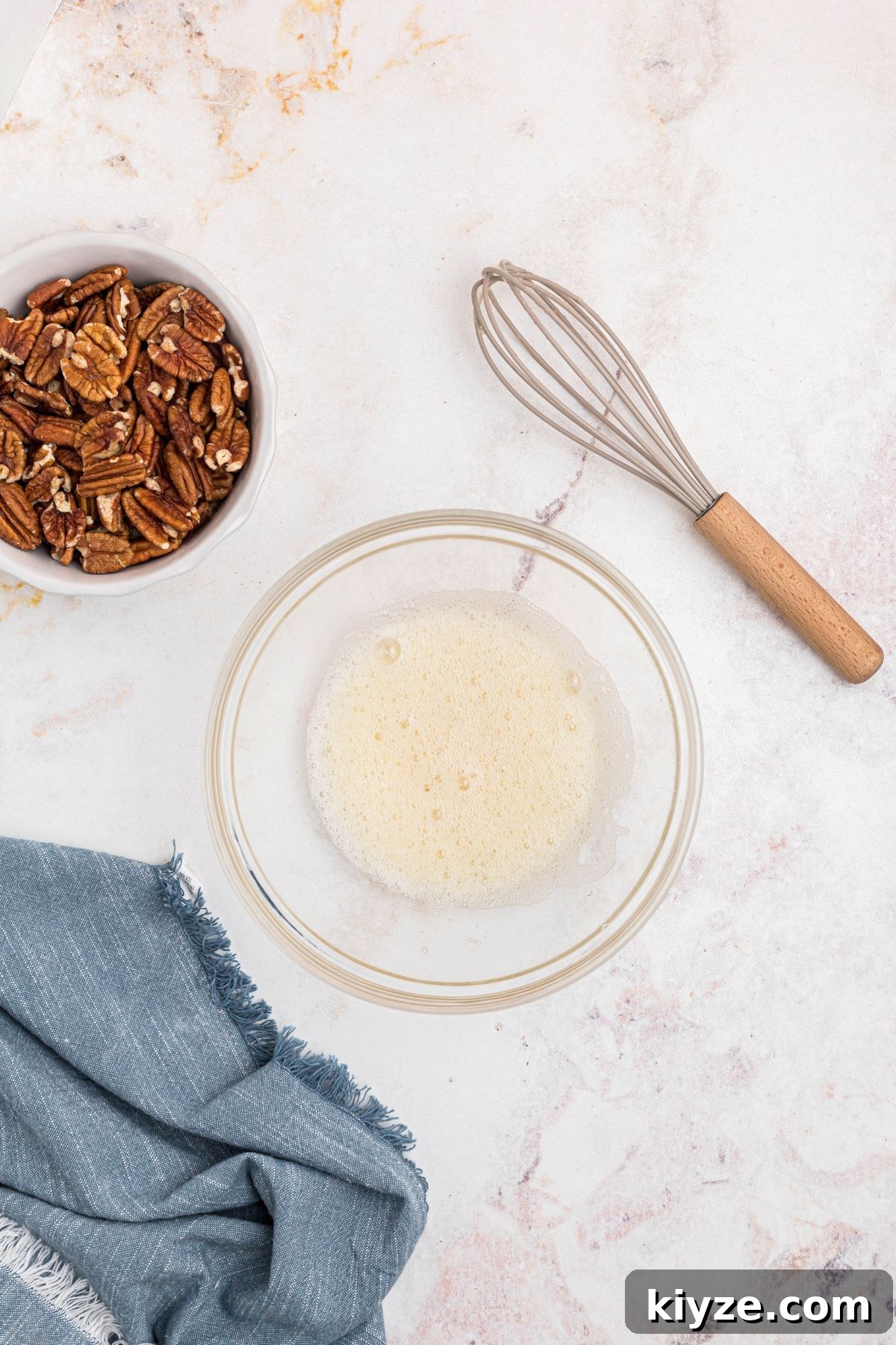 Cinnamon Sugar Candied Pecans Recipe for Snacking & Gifts 4 Egg white whisked with water in a clear glass bowl.