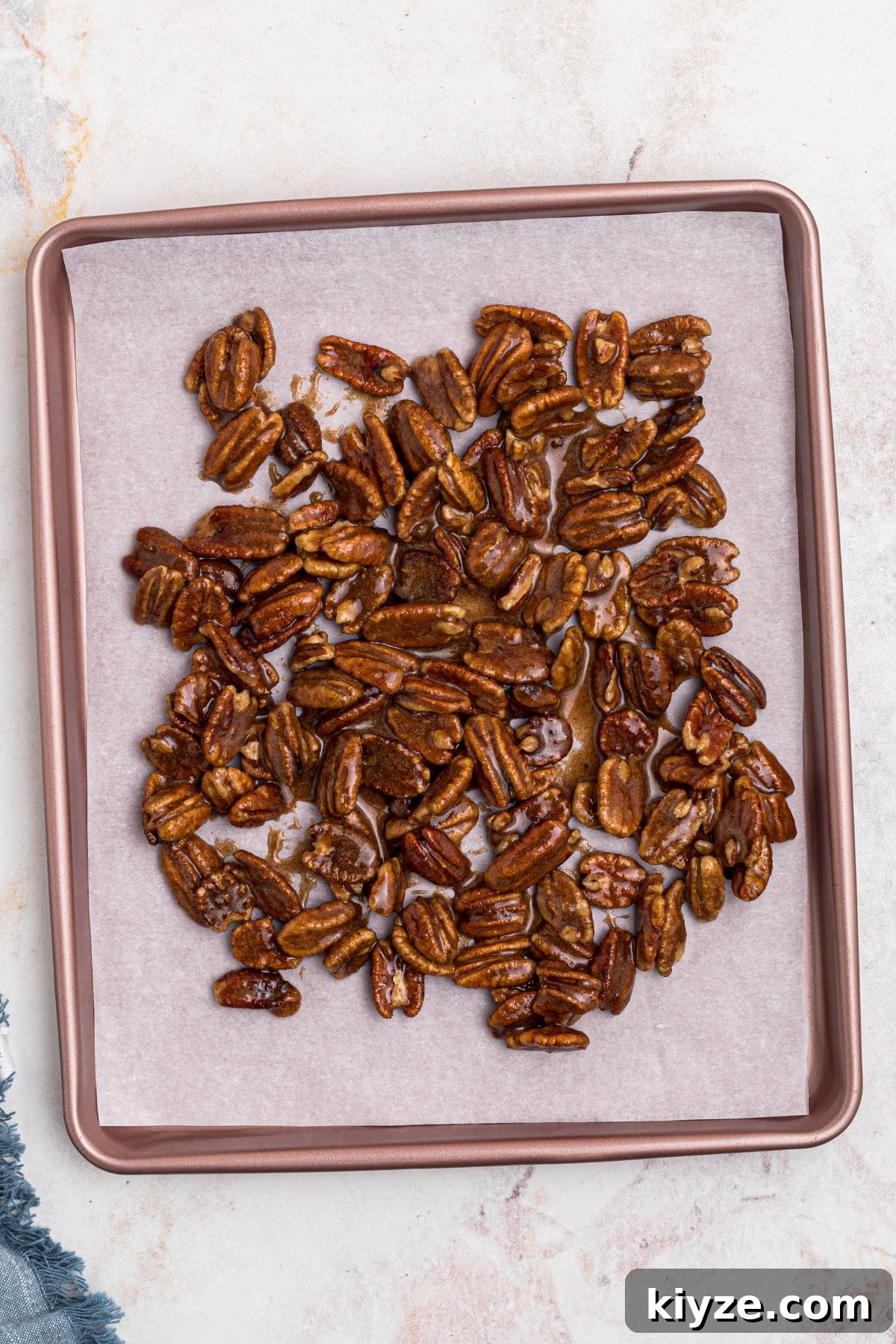Cinnamon Sugar Candied Pecans Recipe for Snacking & Gifts 8 Coated pecans spread onto baking sheet, lined with parchment paper, before baking.