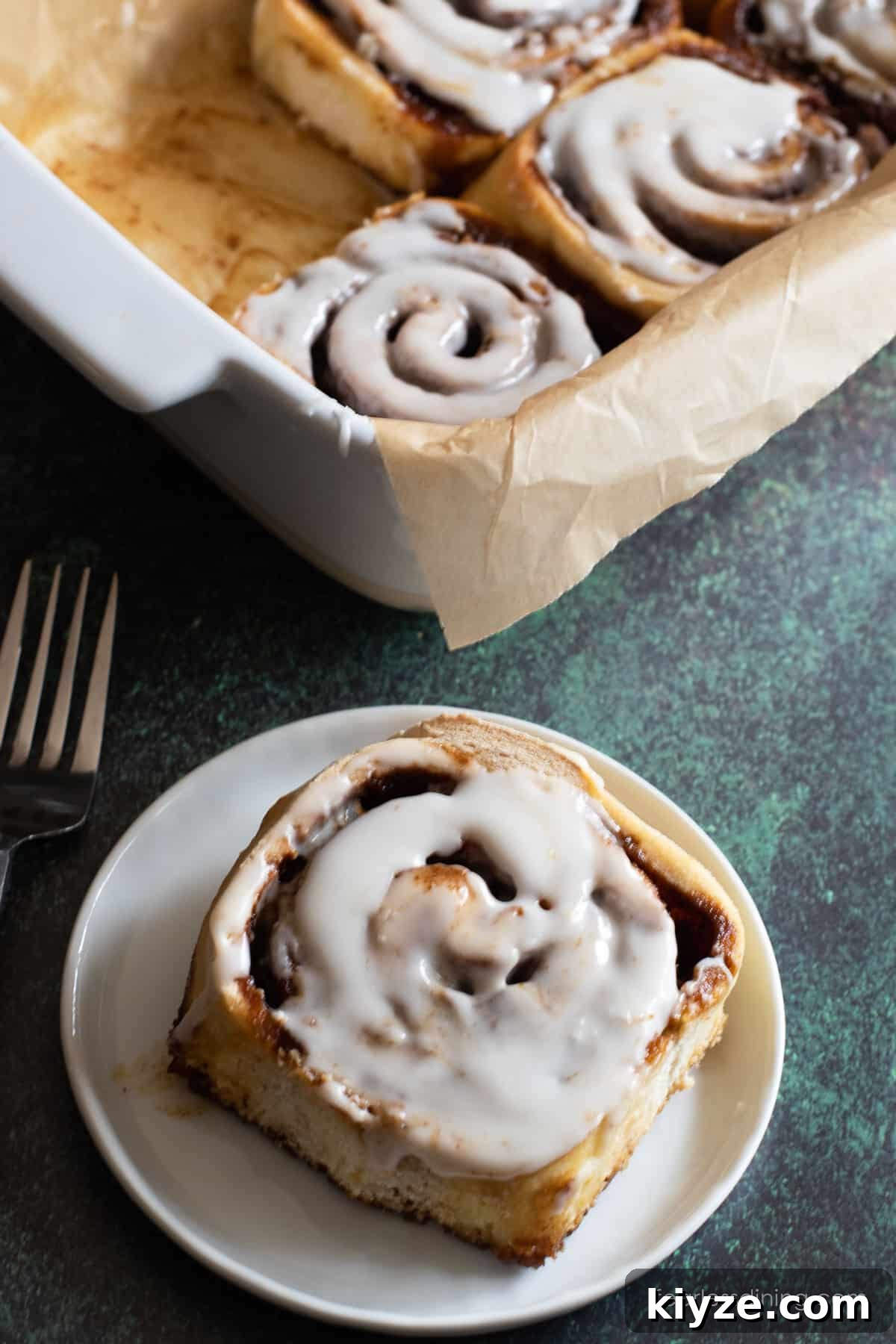 Gluten-Free Gingerbread Cinnamon Rolls Recipe 10 A gluten free gingerbread cinnamon roll on a small white plate.