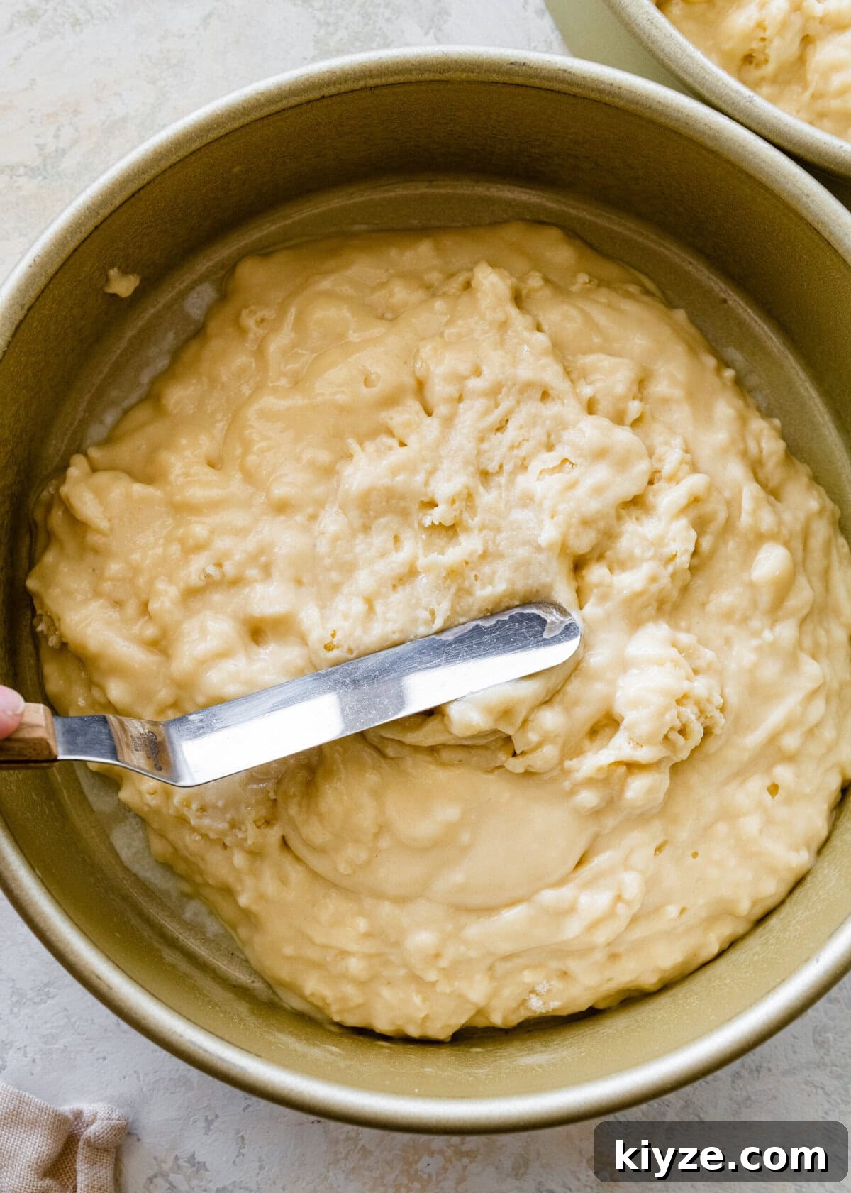 Italian Cannoli Cake Recipe: Classic Sicilian Dessert Guide 10 A person spreading cake batter in a cake pan.