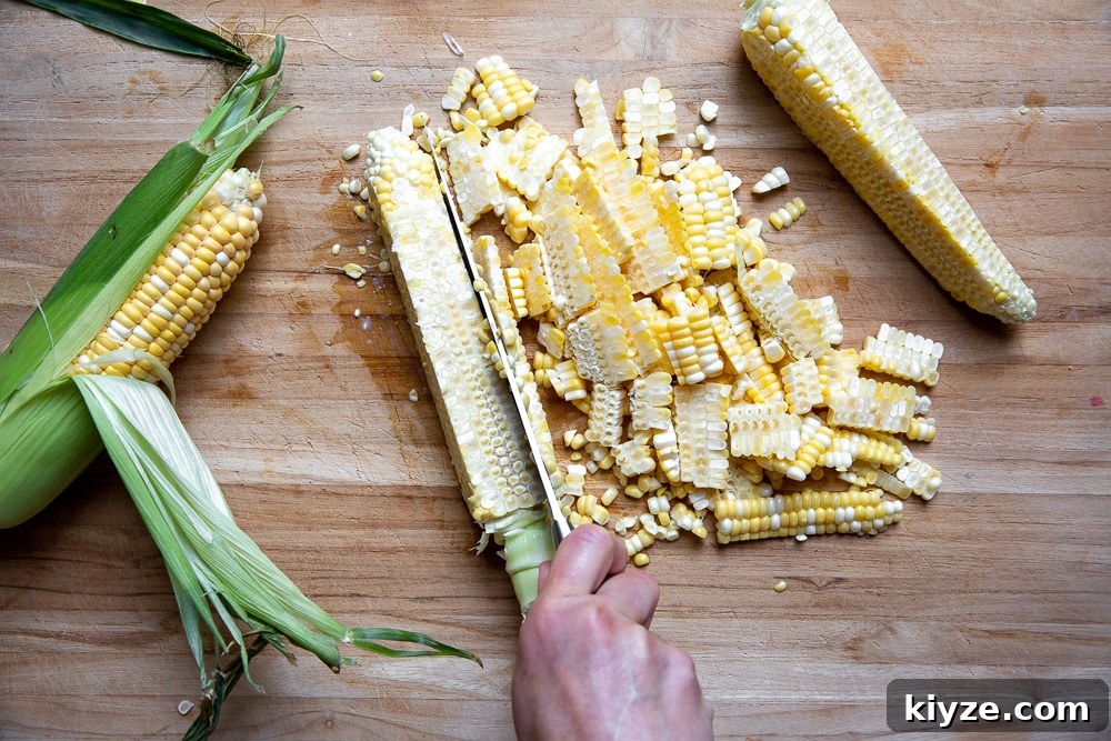 Jalapeño Feta Elote Dip Recipe for Parties and Game Day 8 Process shot showing how to cut corn kernels off the cob.