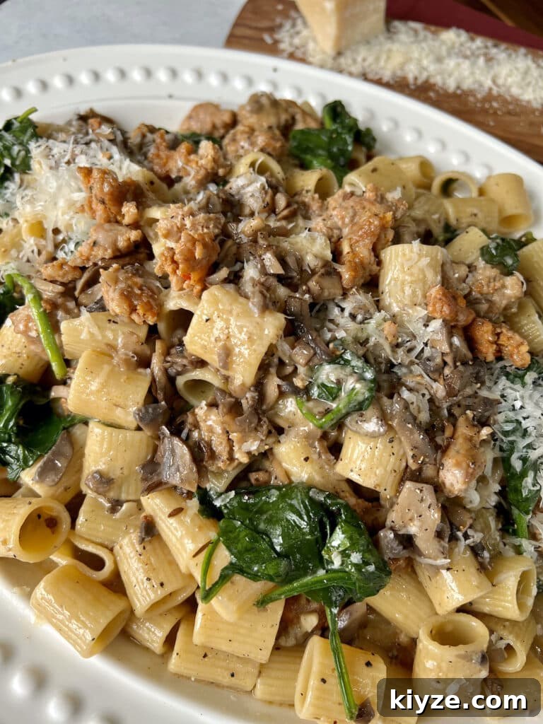 Creamy Pasta Norcina with Italian Sausage and Truffle Oil 4 Norcina Pasta on white platter with grated parmesan in background.