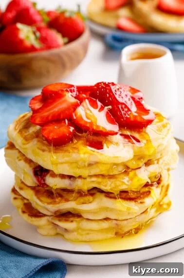 Crispy Cinnamon Churro Waffles Recipe 13 A stack of strawberry pancakes topped with chopped strawberries.