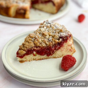 Almond Raspberry Layer Cake with Fresh Raspberry Glaze 15 a single slice of almond raspberry cake on a plate.