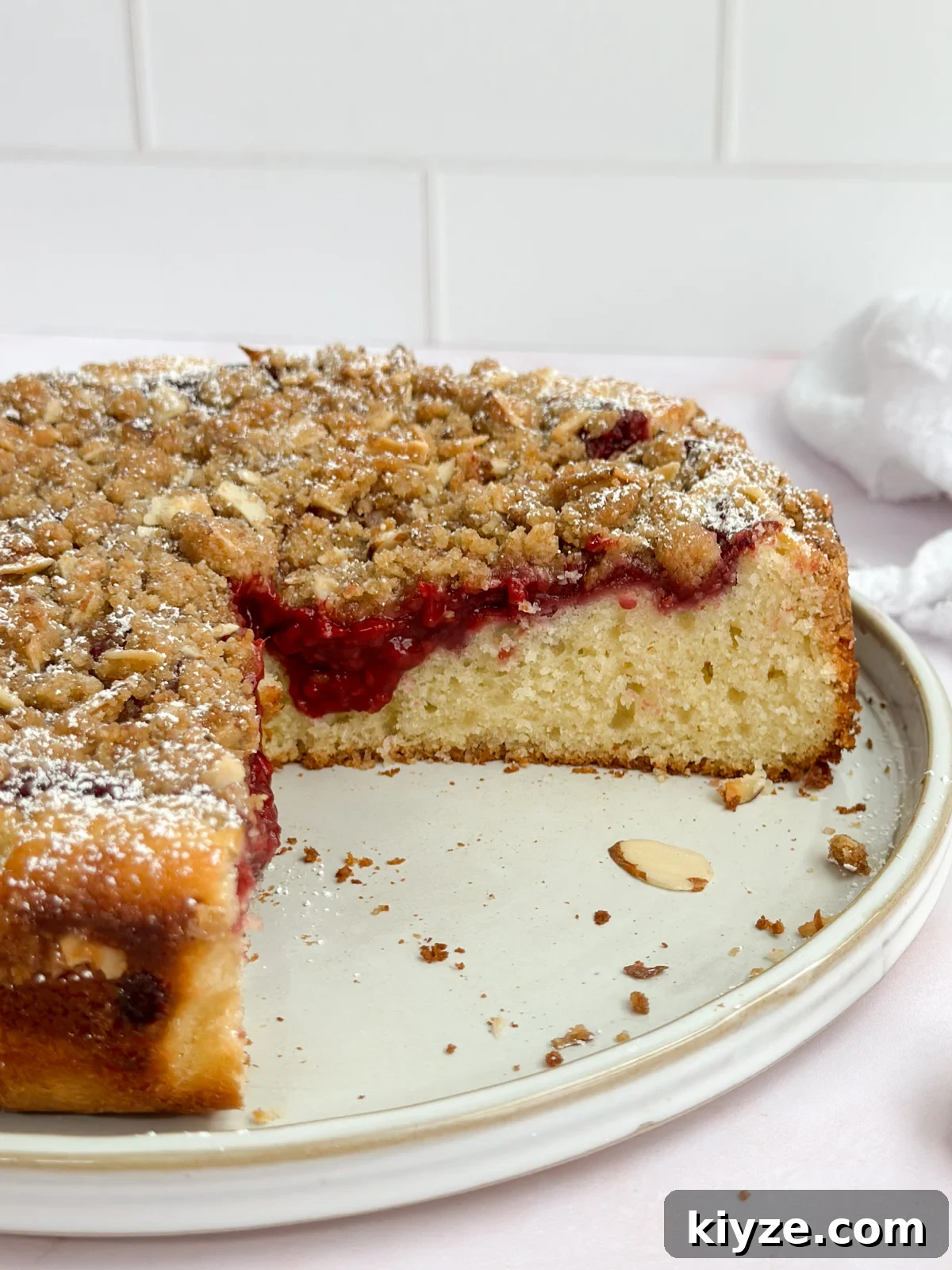 Almond Raspberry Layer Cake with Fresh Raspberry Glaze 3 showing inside the cut almond raspberry cake to see the inside.