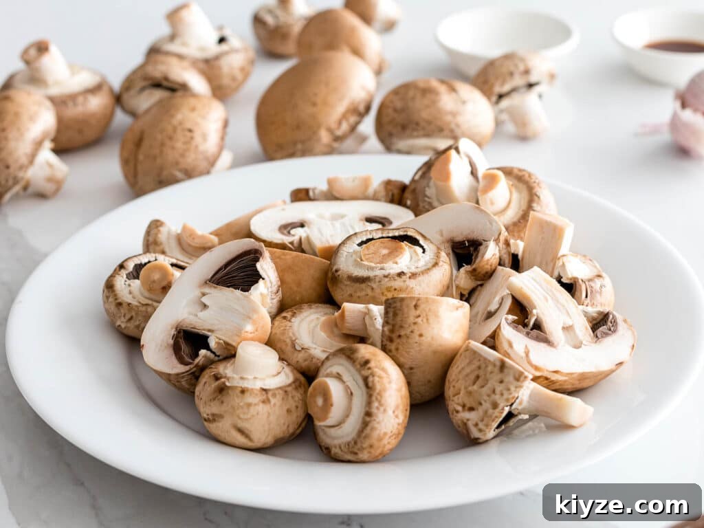 Garlic Butter Sautéed Mushrooms Recipe — Quick Flavorful Side 10 baby portabello mushrooms washed and prepped on a white plate