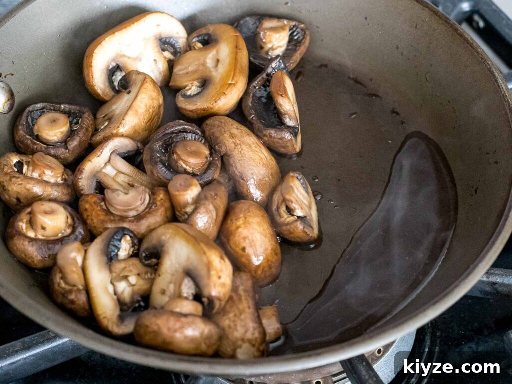 Garlic Butter Sautéed Mushrooms Recipe — Quick Flavorful Side 11 mushrooms releasing liquid after being dry sauteed in a pan