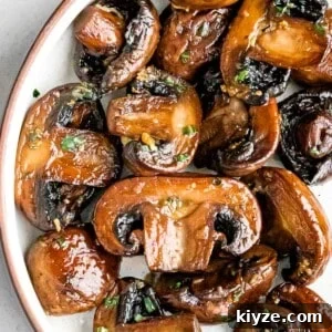 Garlic Butter Sautéed Mushrooms Recipe — Quick Flavorful Side 9 close up of sauteed mushrooms with garlic butter and chopped parsley in a white bowl