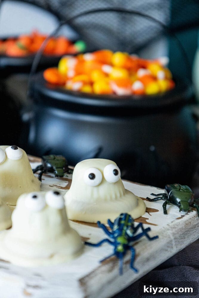 White Chocolate-Dipped Ghost Cookies: Spooky Halloween Treats 2 A tray of White Chocolate Dipped Ghost Cookies with candy surprises inside.
