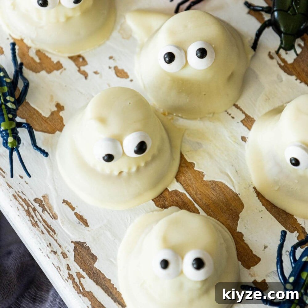 White Chocolate-Dipped Ghost Cookies: Spooky Halloween Treats 3 cookies dipped in white chocolate with candy eyes to look like ghosts