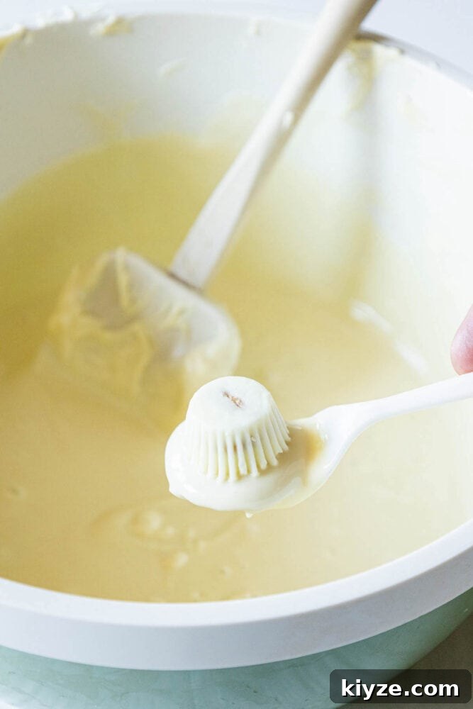White Chocolate-Dipped Ghost Cookies: Spooky Halloween Treats 6 golden oreo on a spoon dipped in white chocolate