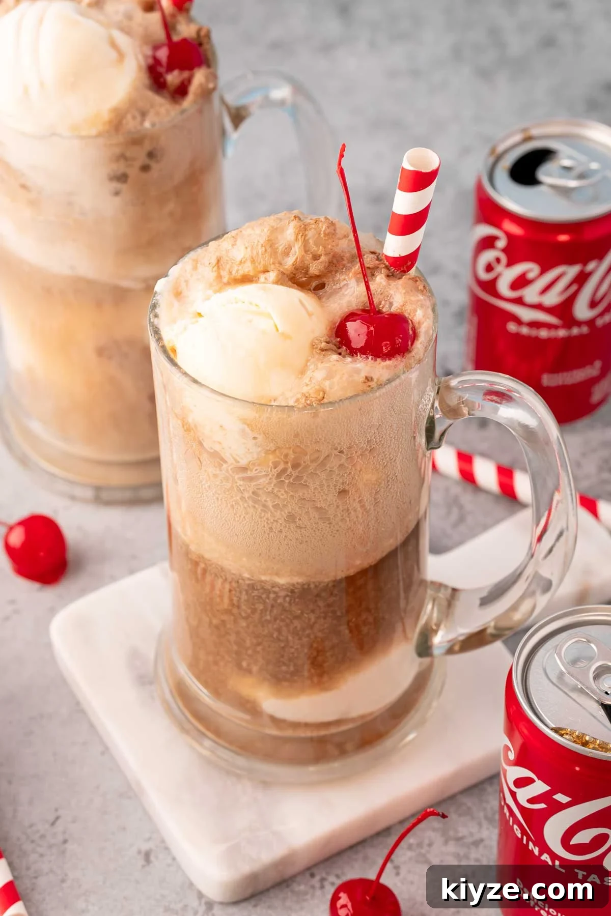 Classic Coke Float Recipe: How to Make the Iconic Soda Float 5 Two beer steins filled with coke floats with coke cans around them.