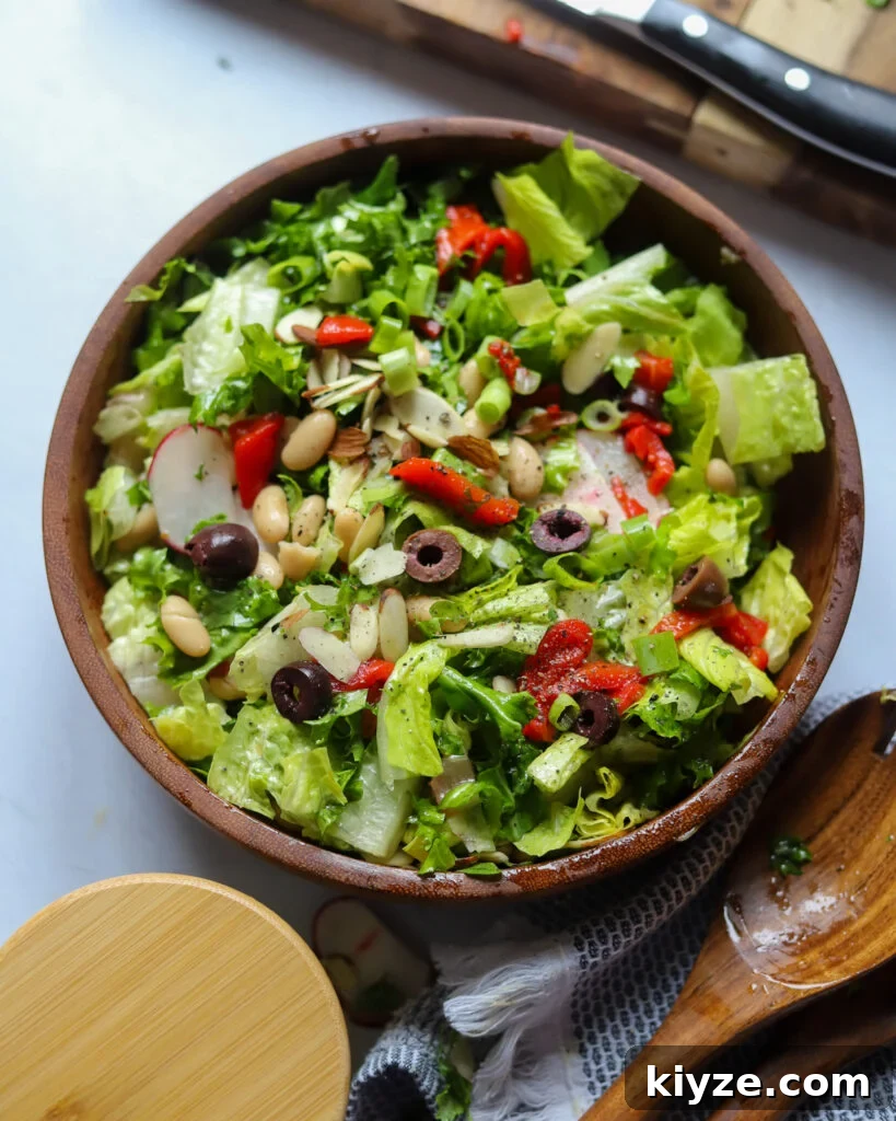 18 Flavorful Vegan Bean Salad Recipes for Every Occasion 14 overhead view of a garden salad with olives, red peppers, red onion, radishes, and beans with an oregano vinaigrette.