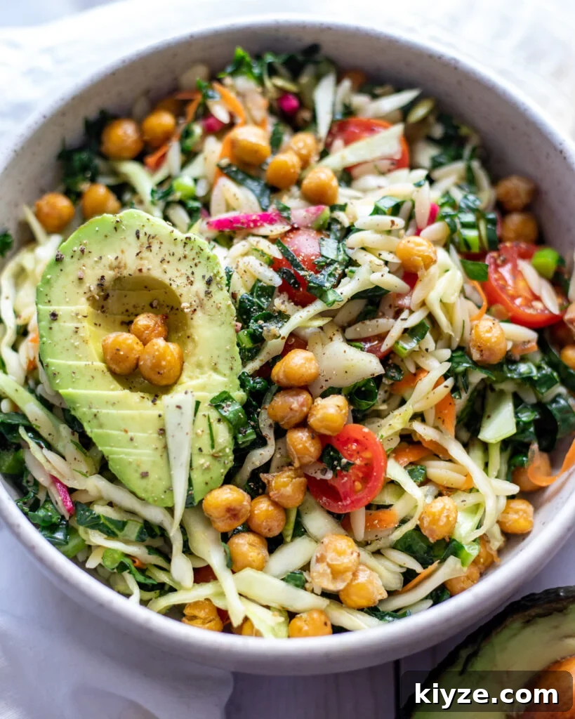 18 Flavorful Vegan Bean Salad Recipes for Every Occasion 19 image of Winter Orzo Pasta Salad in a white bowl with sunlight streaming over it.