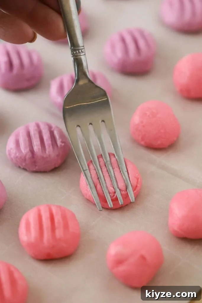 Cream Cheese Mint Candies Recipe: Soft Homemade Mints in Minutes 5 A fork pressing the top of small balls of cream cheese mints dough.
